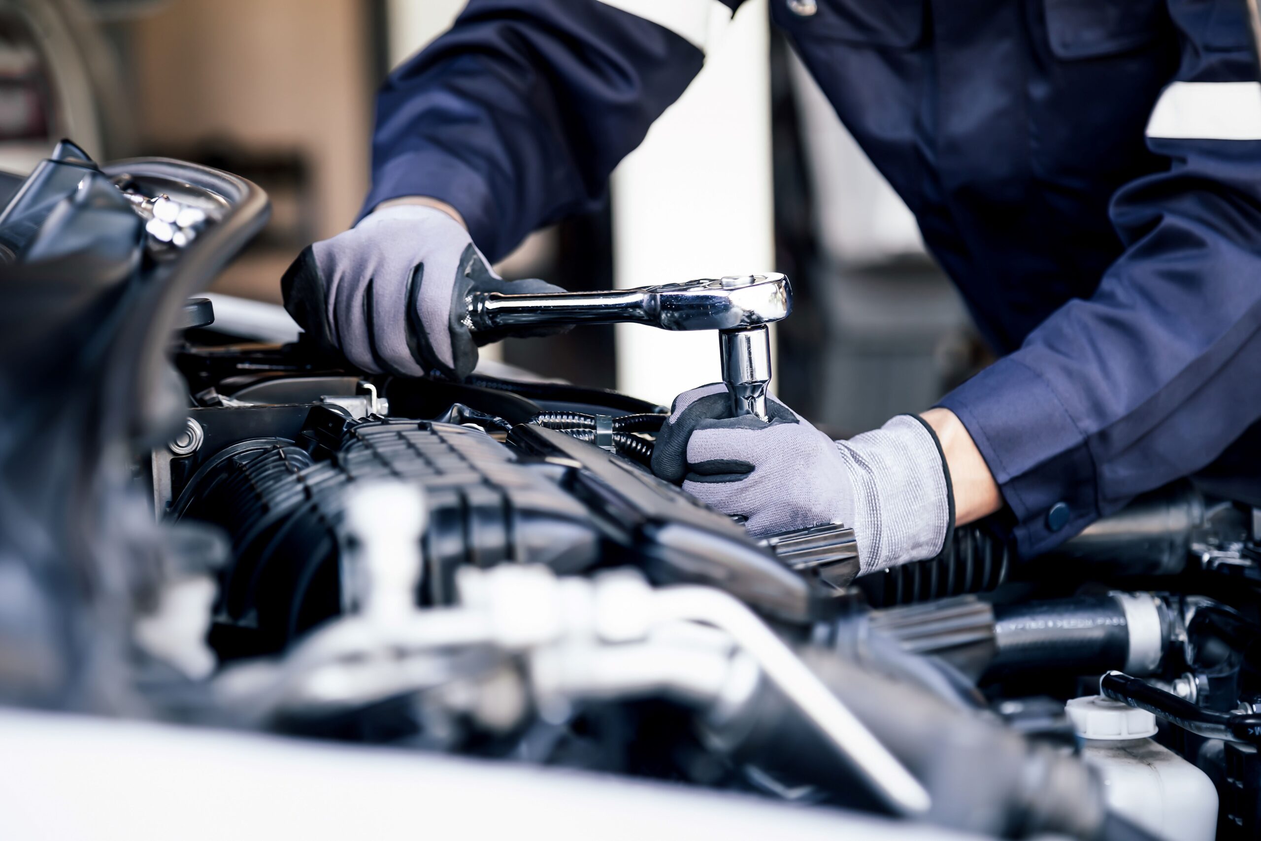 Eine Person zieht eine Schraube nach an einem Auto 