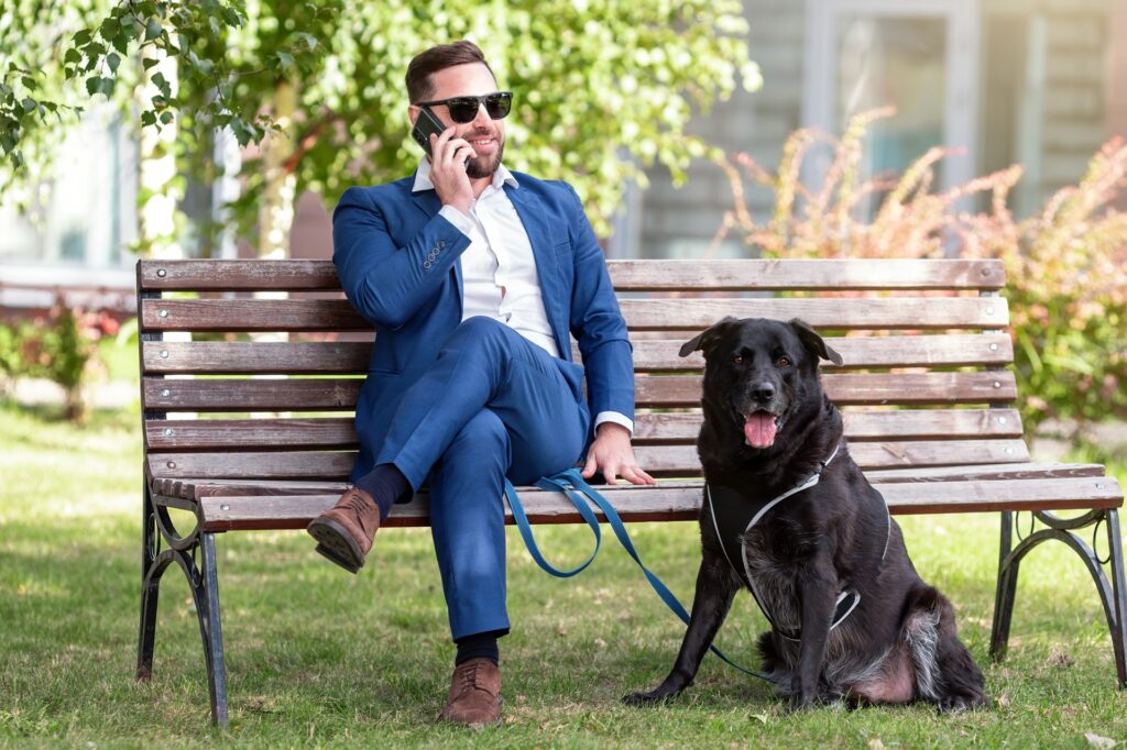 Mann im Anzug telefoniert mit Hund | Nierendiät beim Hund